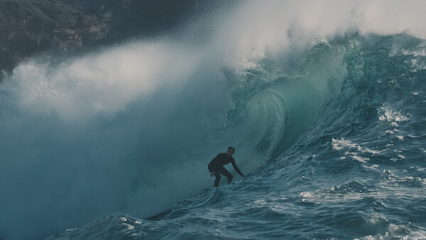A person surfs through a big wave